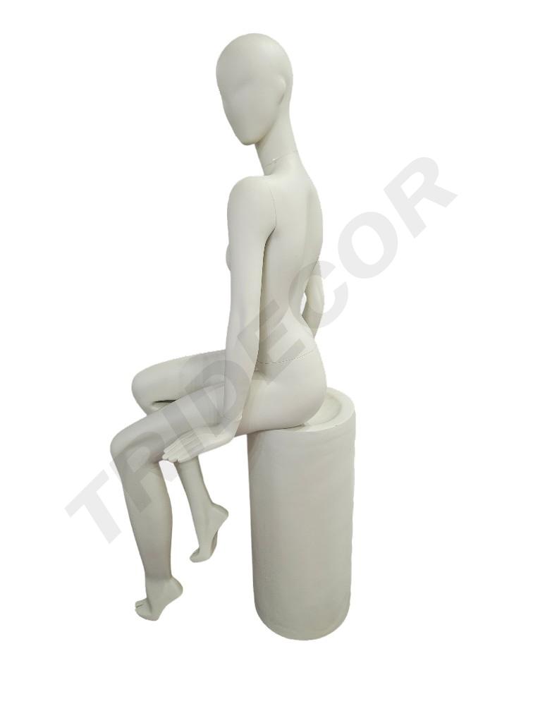 Female mannequin sitting in cream white