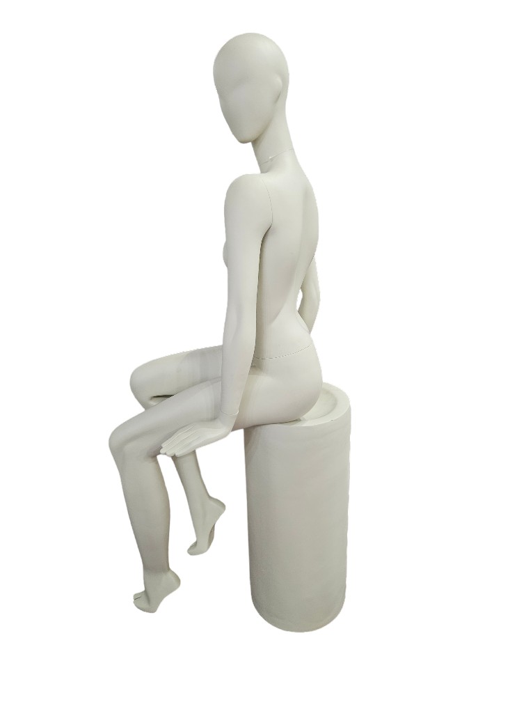 Female mannequin sitting in cream white